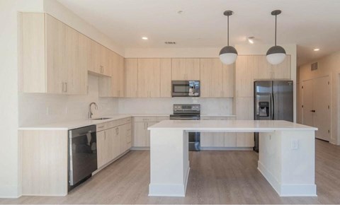 A modern kitchen with wooden cabinets and a central island.