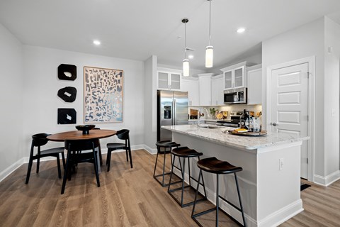 an open kitchen and dining area with a marble counter top