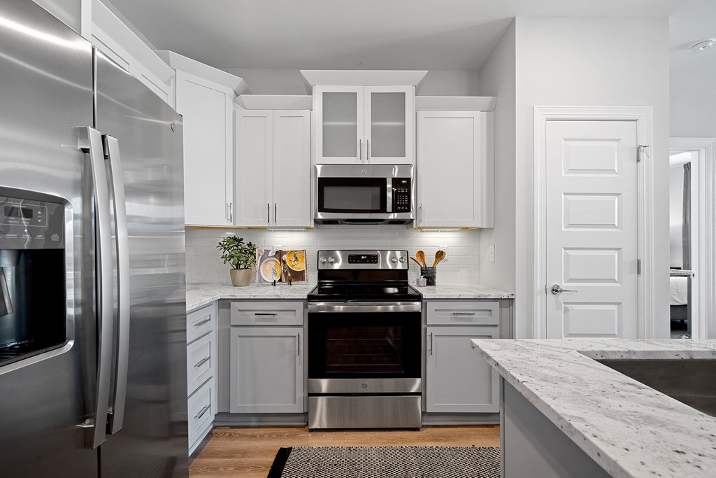 a kitchen with white cabinets and stainless steel appliances