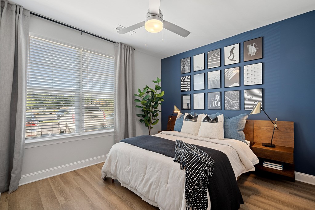 a bedroom with a blue wall and a large window