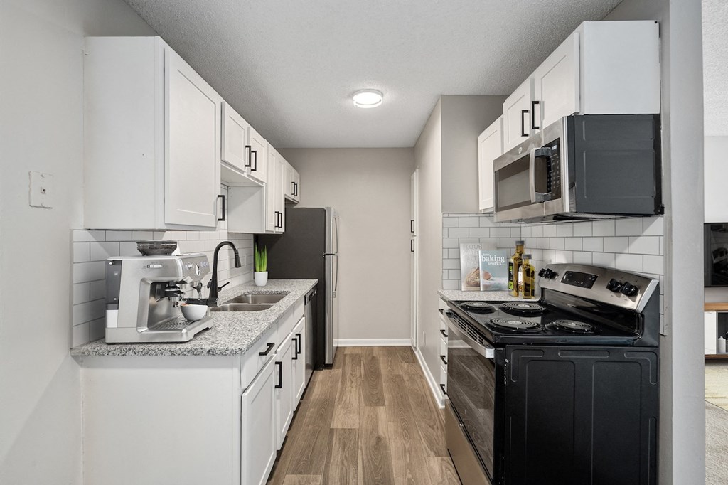 a kitchen with white cabinets and black appliances