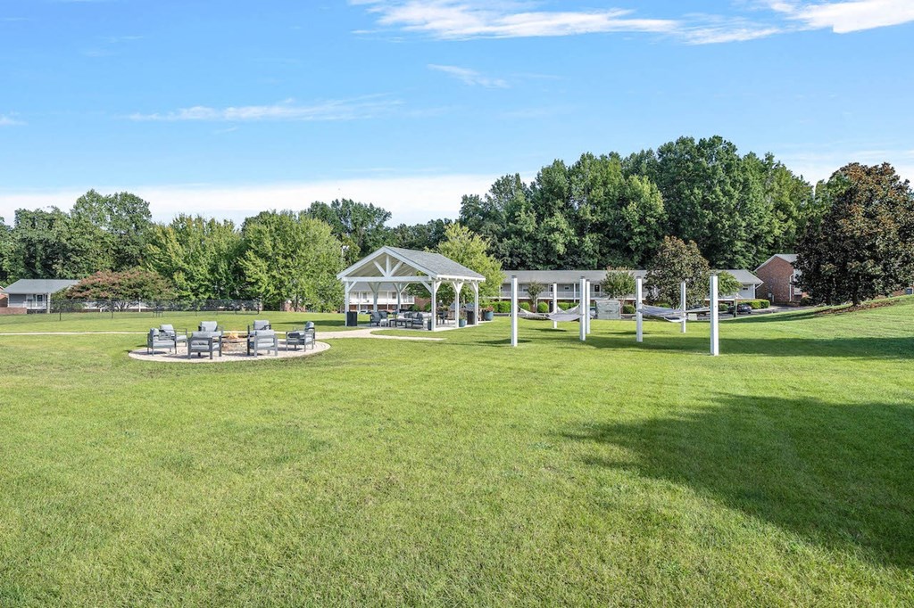 a park with picnic tables and a pavilion on the grass