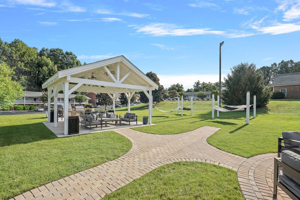 a picnic area with a pavilion and benches in a park