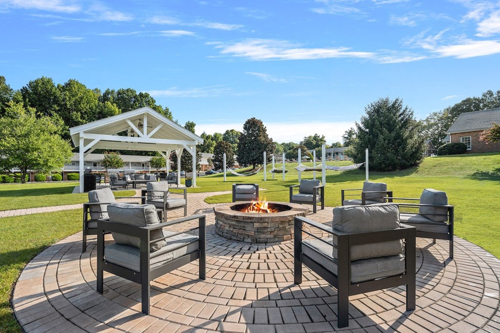 a patio with chairs and a fire pit