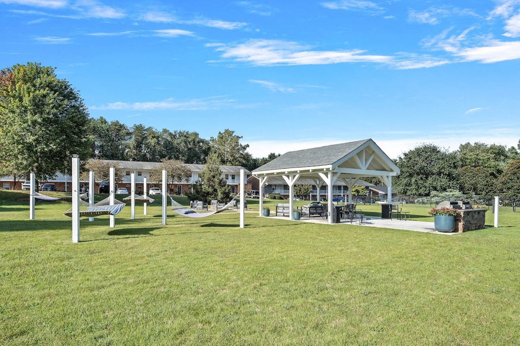 a group of hammocks and a pavilion in a park