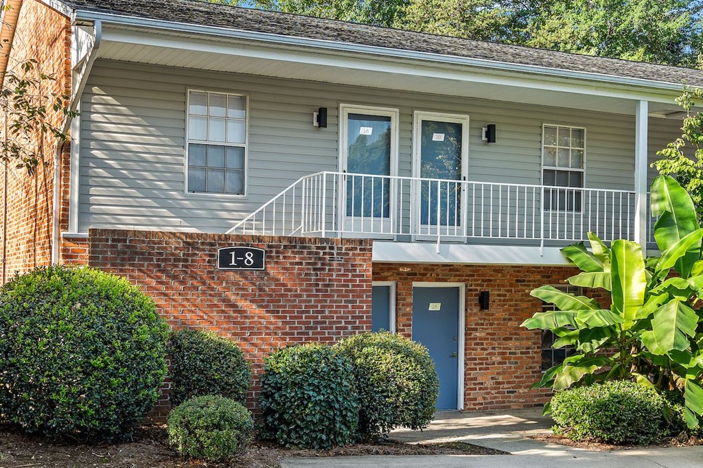 the front of a house with a porch and a blue door