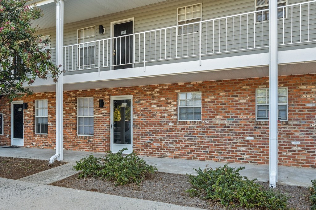 a brick building with a balcony and a front door