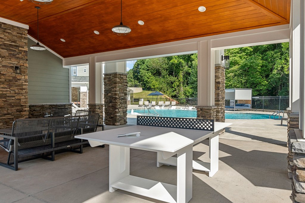 Amenities a patio with a ping pong table and a pool in the background