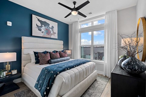 A bedroom with a large bed and a ceiling fan.