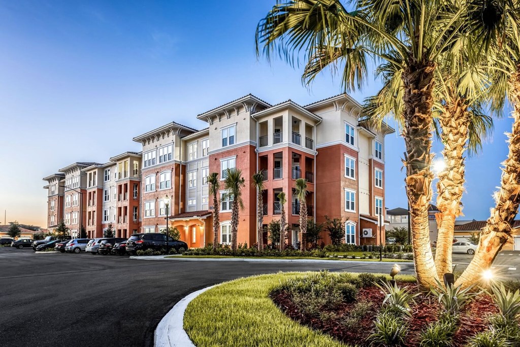 a street view of an apartment building with palm trees