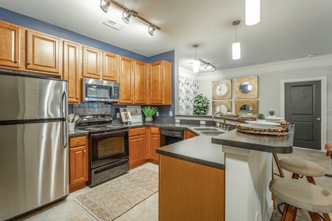 A kitchen with wooden cabinets and a stainless steel refrigerator.