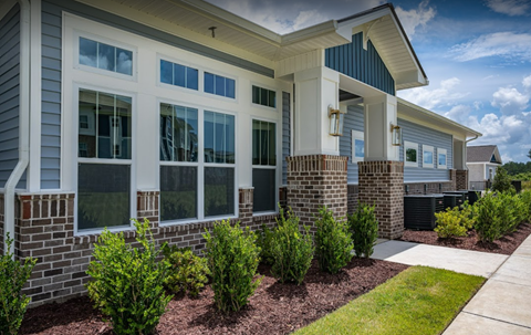 a home with a sidewalk and landscaping in front of it