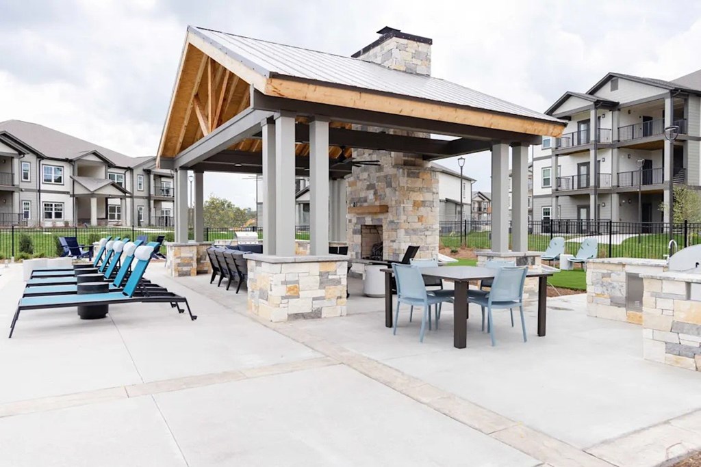 A patio with a table and chairs and a fireplace at the Wilmont at Hendersonville Apartments in Hendersonville,NC