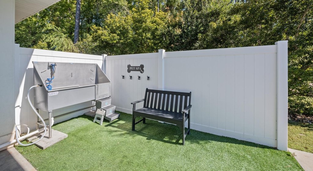 A white fence with a black bench and a white slide.