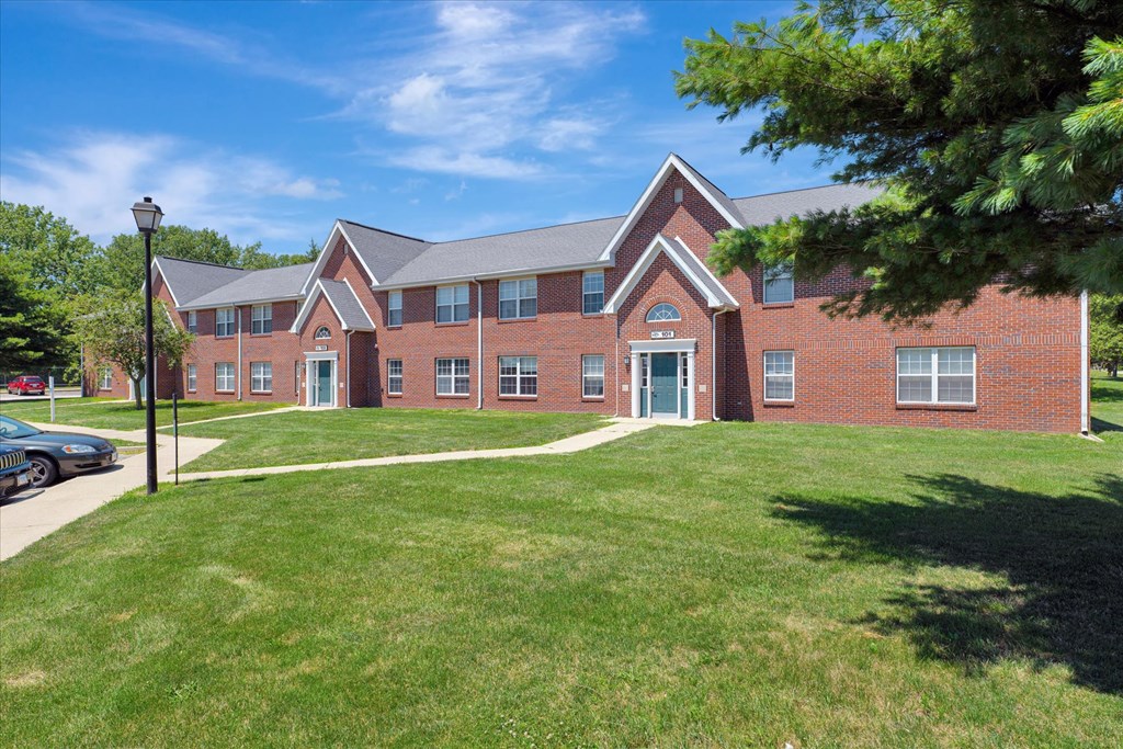 a large brick building with a lawn in front of it