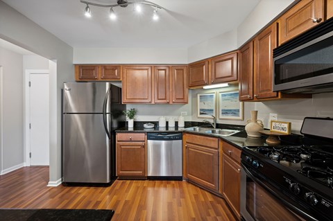 A kitchen with wooden cabinets and a black stove top oven.