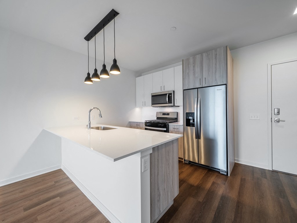 a kitchen with an island and stainless steel refrigerator