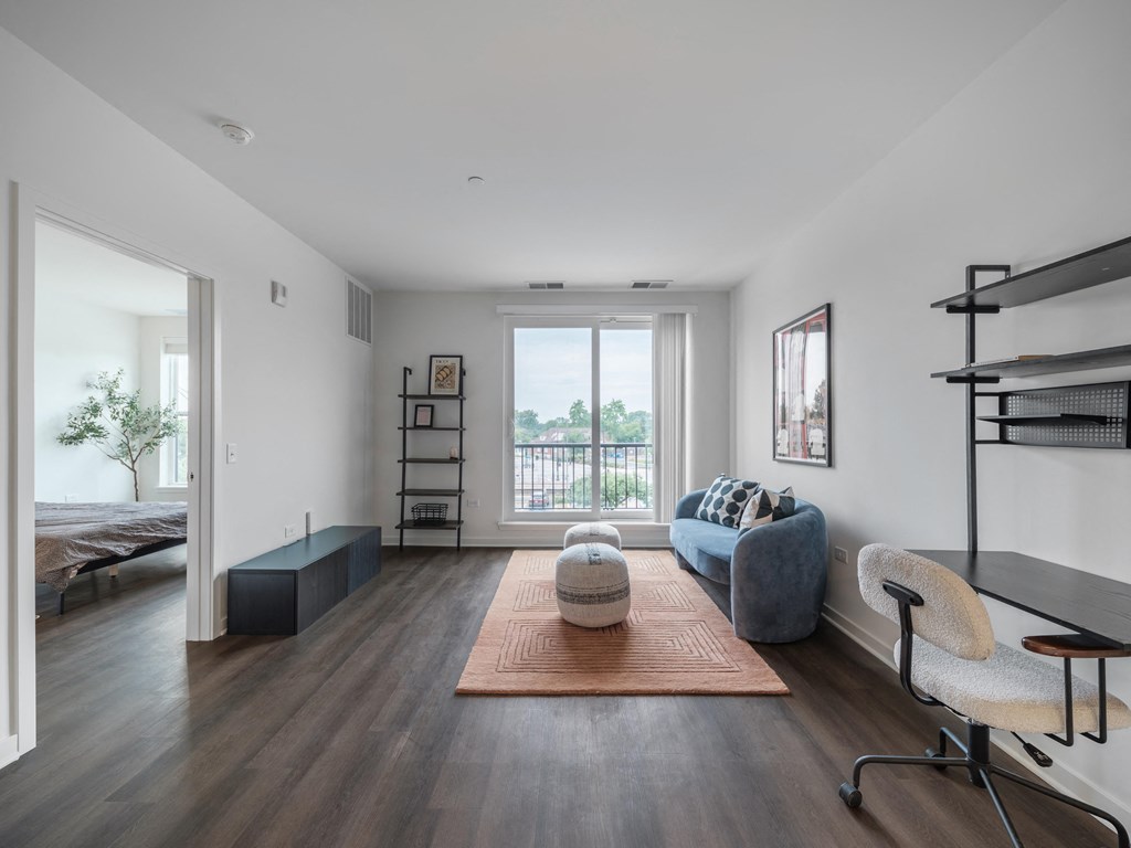 a living room with a couch and a chair and a large window