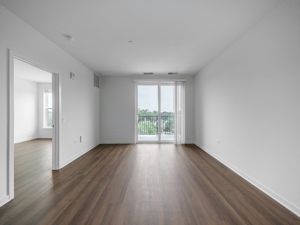 an empty living room with white walls and wood floors