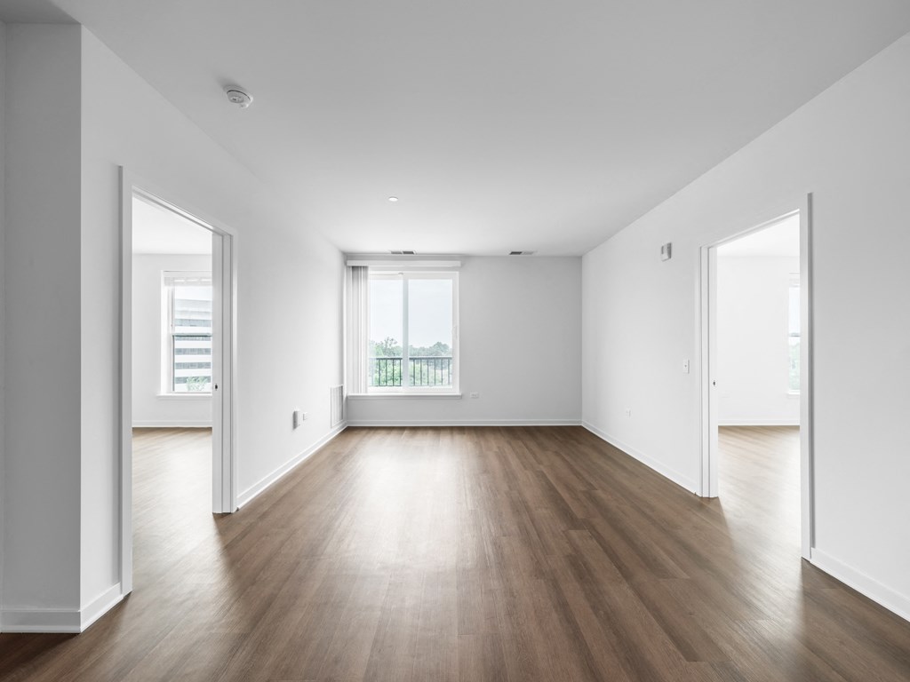 an empty living room with white walls and wood floors