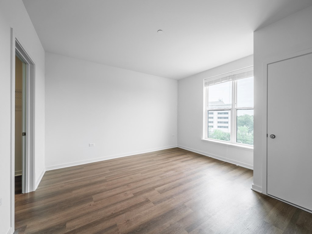 an empty living room with white walls and a window