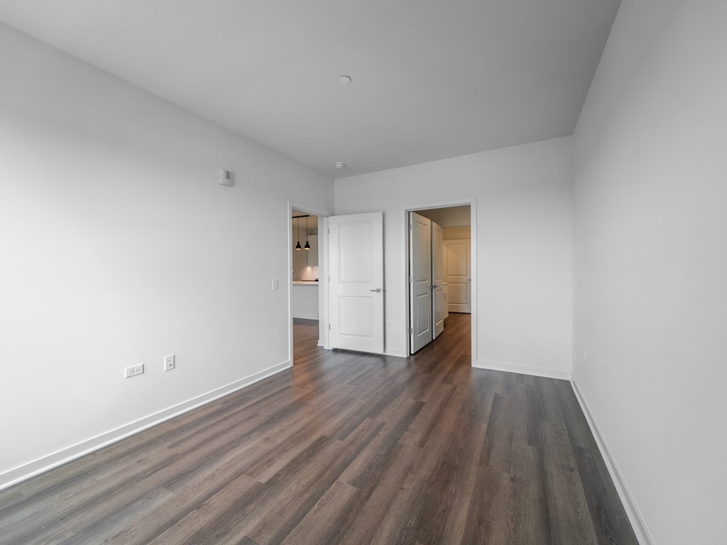 an empty living room with white walls and wood flooring