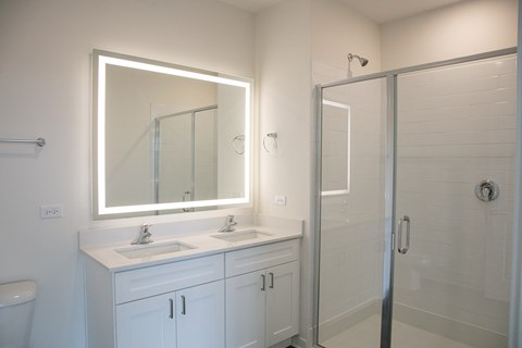 a bathroom with two sinks and a shower