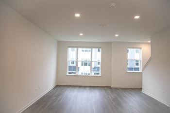 a living room with wood floors and a large window at Enclave Crystal Lake Townhomes and Apartments, Crystal Lake