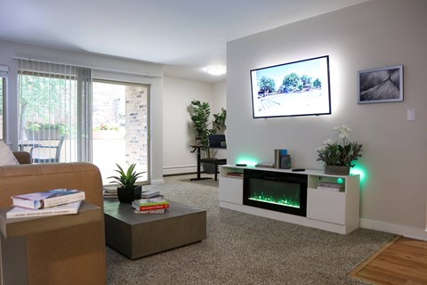 A living room with a flat screen TV mounted on the wall.