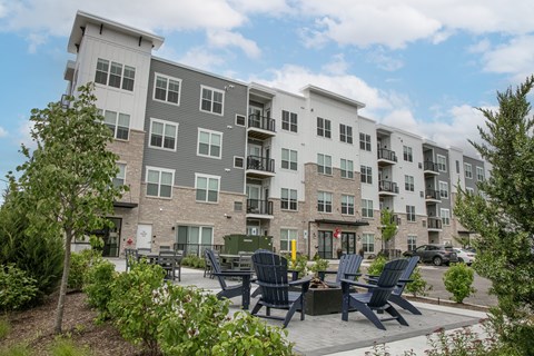 an outdoor patio with chairs and tables in front of the apartment building at Enclave Crystal Lake, 60014
