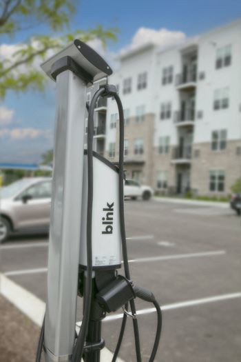 a gas pump in a parking lot in front of an apartment building at Enclave Crystal Lake Townhomes and Apartments, Crystal Lake, 60014