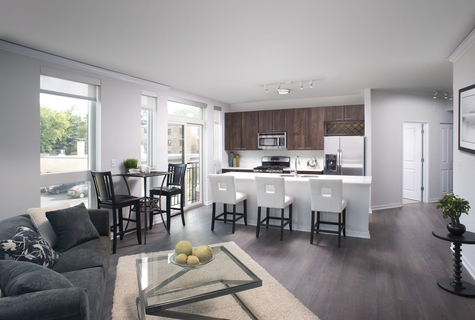 A modern kitchen and dining area with a glass table and chairs.