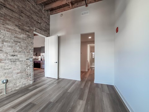 A room with a wooden floor and a brick wall.