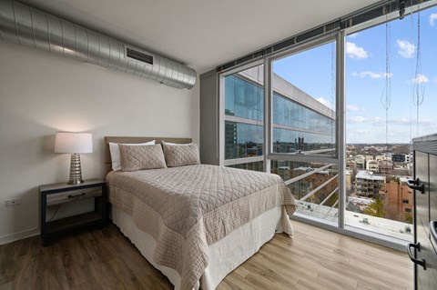 A bedroom with a large bed and a view of the city.