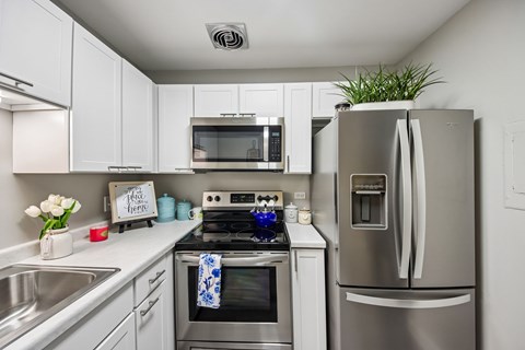 A modern kitchen with a stainless steel refrigerator and oven.