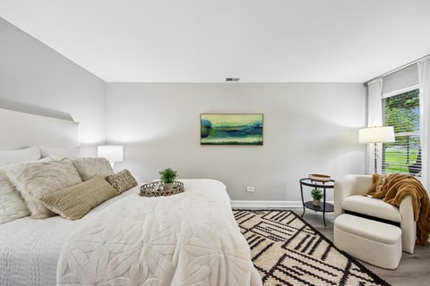 A bedroom with a large bed and a painting on the wall.