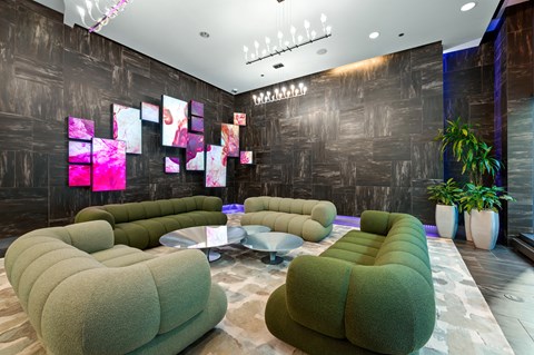 A modern living room with a grey sofa and a glass table.