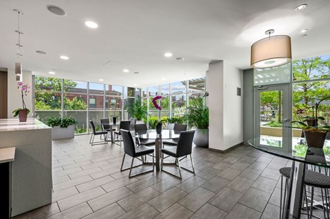 a seating area with a table and chairs in the atrium of a building at Halsted Flats Apartments, Chicago, Illinois
