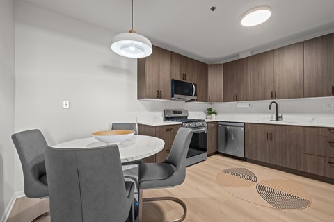 A modern kitchen with a dining table and chairs.