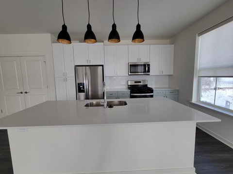 A kitchen with white cabinets and a large island.