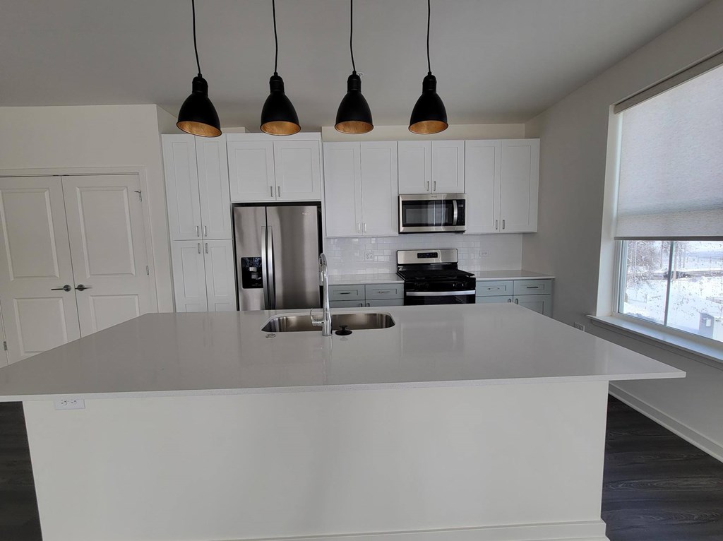 A kitchen with white cabinets and a large island A kitchen with white cabinets and a large island at Enclave Crystal Lake, Crystal Lake, Illinois, 60014