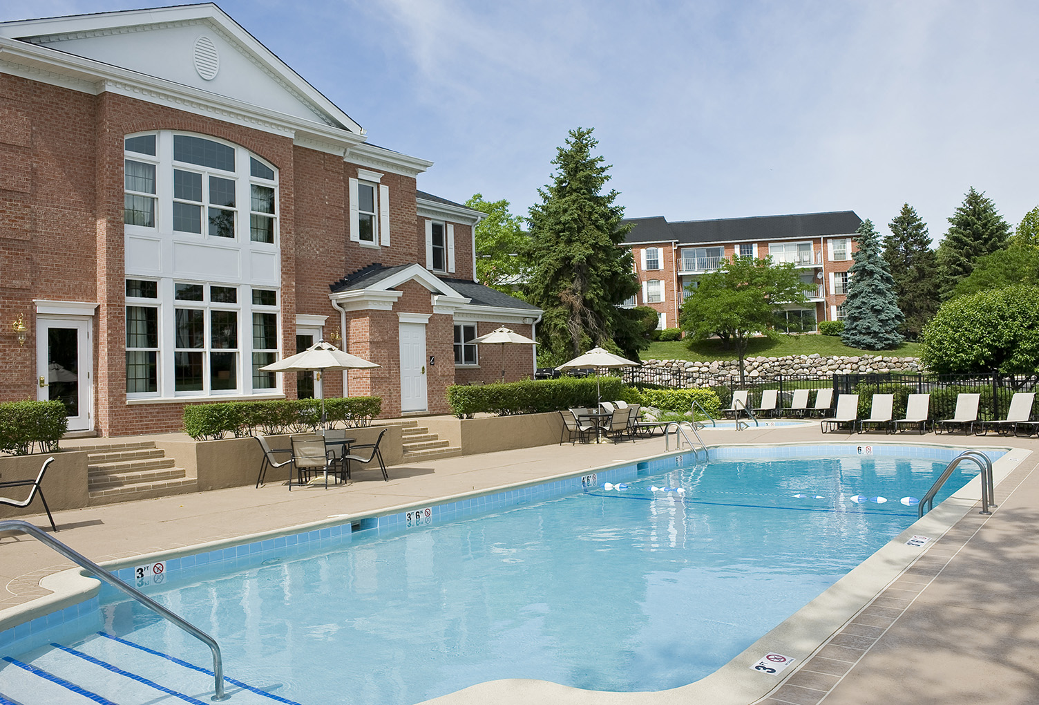 Outdoor swimming pool with sundeck and lounge chairs at Versailles on the Lakes Schaumburg Apartments, Schaumburg, Illinois