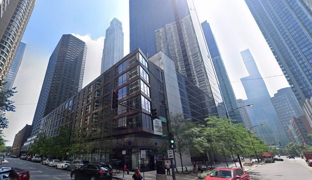 a building in front of tall buildings on a city street