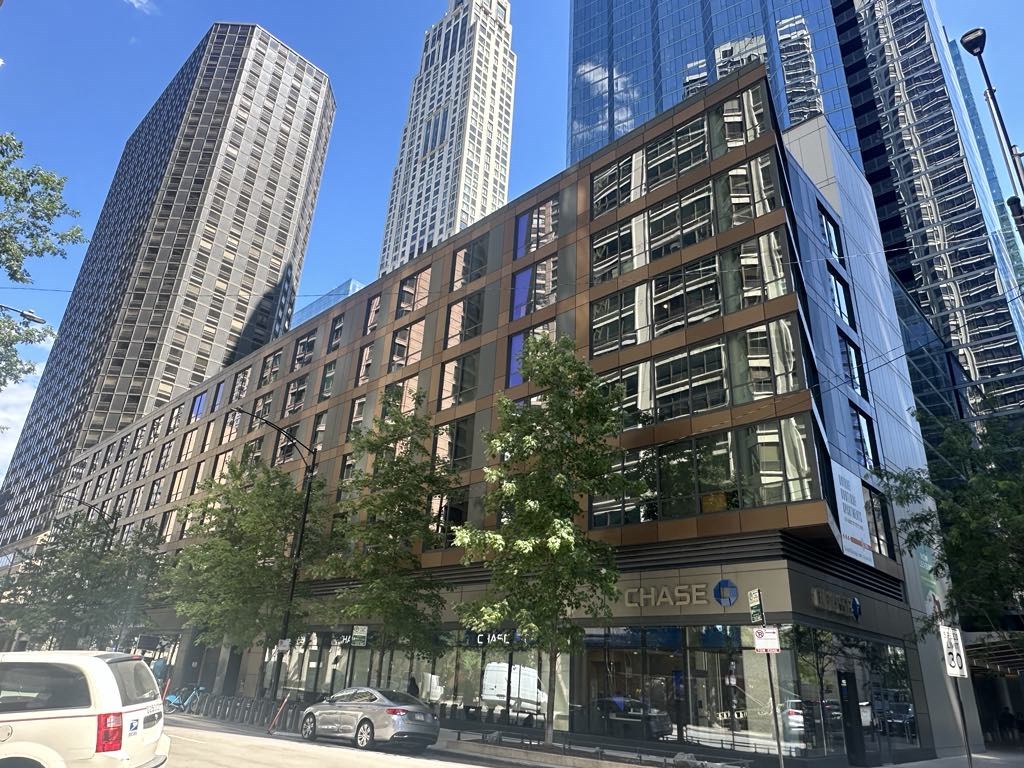 a building on a city street with tall skyscrapers