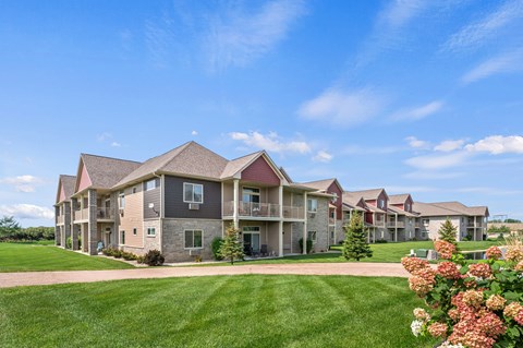 A row of houses with a green lawn in front.