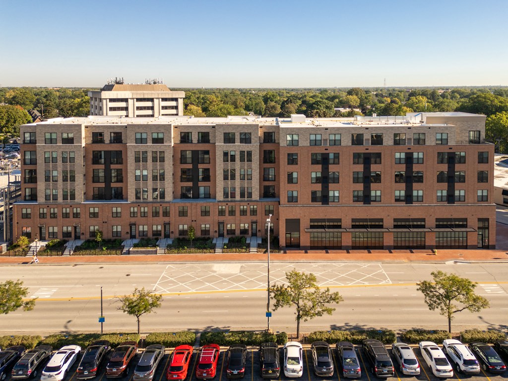 an aerial view of a parking lot with cars in front of a building