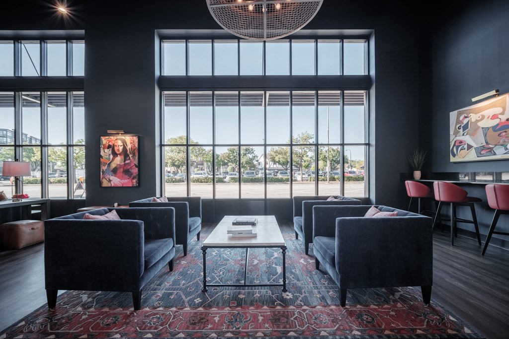 a living room with couches and a coffee table and large windows