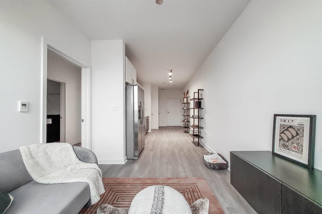 A living room with a grey couch and a rug.