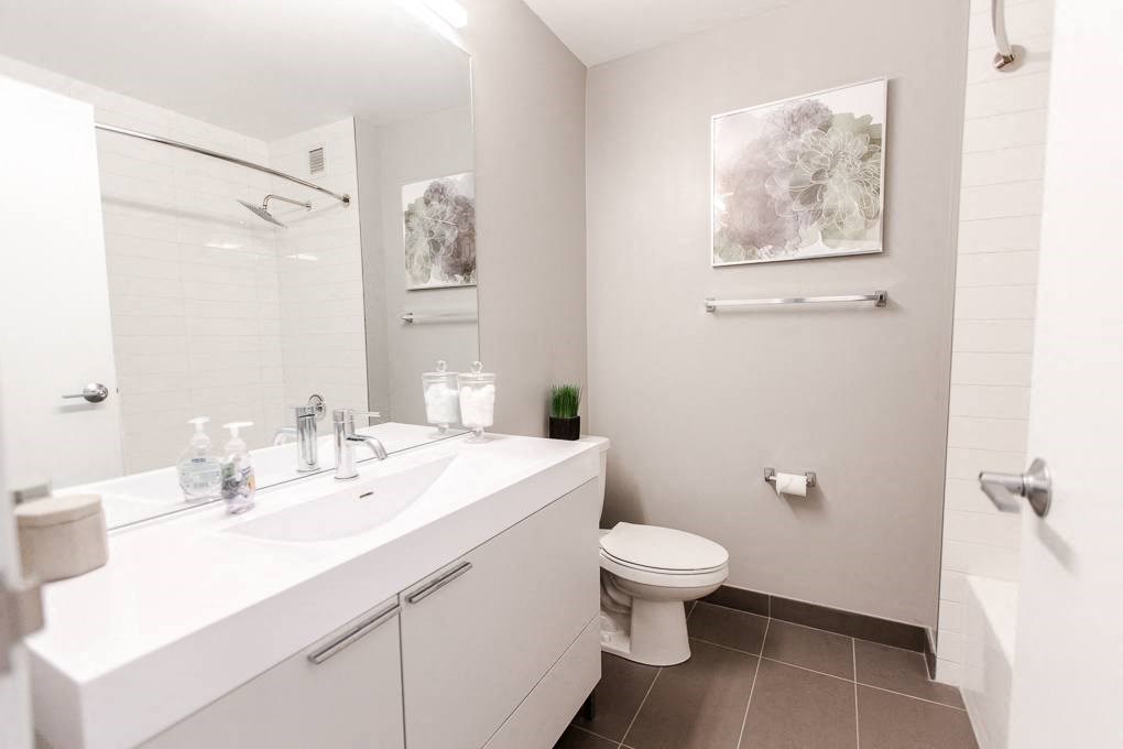 a bathroom with a sink toilet and a mirror at The Kent, Illinois