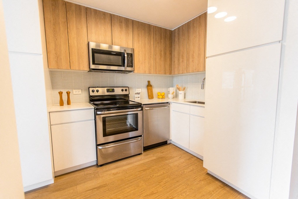 a kitchen with stainless steel appliances and white cabinets at The Kent, Chicago, IL, 60614